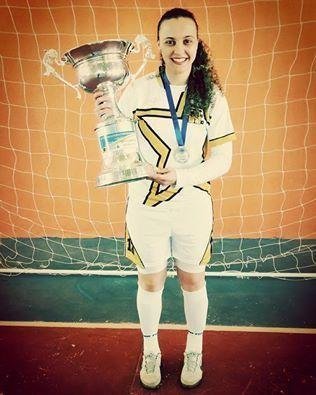 Neide Oliveira holding her futsal trophy
