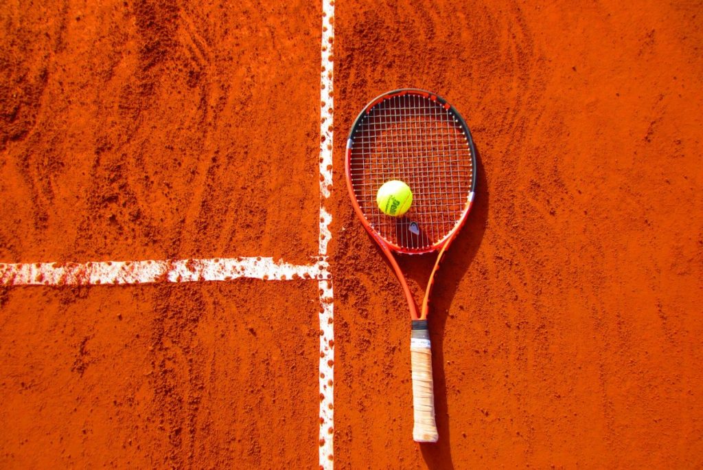 racket and ball on clay court