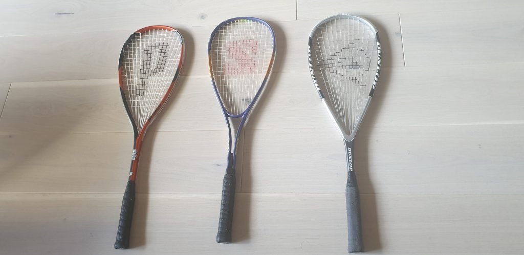 three history of squash racquets placed on the ground